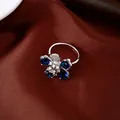 Macro view showing detailed design of silver flower ring with blue pear-shaped zircons - Ring / Silver & Blue