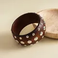 Nahaufnahme eines Vintage-Harzarmreifens in Braun mit polierten silbernen Metallnieten - 手镯-银色-棕色