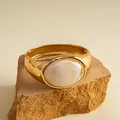 Detailansicht eines vintage Goldarmreifs mit einer eleganten weißen Marmorharz-Einlage - Eco Gold-Weiß