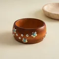 Detailansicht eines Vintage-Holzarmreifens mit Blumennieten und Türkis-Akzenten - Flower Shaped Vintage Bangle