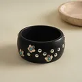 Detailaufnahme eines schwarzen Ethno-Armreifs mit silbernen Blütenakzenten und Metallnieten - Matte Black Silver Flower Bangle