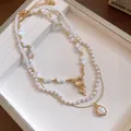 Vue détaillée d'un ensemble de colliers en perles baroques multicouches avec pendentif cœur - Style Rétro Français / Ensemble Collier Or