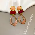 Close-up of vintage geometric acrylic dangle earrings in burgundy and tan colors - Three-Stage Geometric Drop Style (HE35635) / Pink-Red