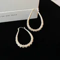 Detail view of silver-tone geometric waterdrop hoop earrings with textured surface - Silver