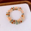 Vue détaillée de bracelets en perles empilés avec des pierres vertes et ambrées - Café-Vert (10mm)