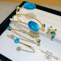 Vue détaillée d'un ensemble bracelet et bague spirale bohème vintage avec cristaux bleus - Bleu Set / Ensemble deux pièces / Or