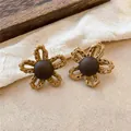 Gros plan sur des boucles d'oreilles vintage en raphia tressé avec centre en bois - Boucles d'Oreilles Clous Tissées (HE35490) / Aiguille en argent / Marron