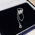 Nahaufnahme einer silbernen Stern-Ohrklemme mit Quaste und funkelnden Steinen - Mehrlagiger Wickelstil / Einzelstück / Silber