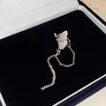 Detailansicht eines funkelnden Schmetterlings-Ohrklemms mit silbernen Ketten in Box - Schmetterling-Design / Einzelstück / Silber