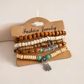 Detail van 6-delige etnische armbandset met houten kralen en zilveren veren hangers. - Koffie-Wit