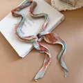 Detail van een vintage geplooide tie-dye sjaalketting met een decoratieve kraal - Ketting / Oranje en Blauw