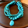 Detailweergave van meerstrengs turquoise kralenketting met een grote druppelhanger - Druppel Hanger / Blauw