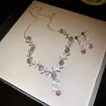 Detailweergave van de fonkelende halsketting en oorbellen set met blad- en bloemhangers - Ketting En Oorbellen Set / Zilver-Donkerroze