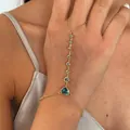 Gedetailleerde close-up van een 18k vergulde hart handketting met blauwe zirkoniasteen. - Goud-Blauw