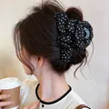 Close-up of a Korean style fabric floral hair claw clip on a bun - Floral Claw Clip / Black