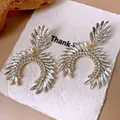 Primer plano de elegantes pendientes de estrás con cristales marquise en tarjeta blanca. - Poste de pendiente de plata-Dorado-Transparente
