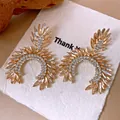 Detalle de pendientes colgantes vintage con cristales champán sobre papel blanco - Poste de plata para pendientes-Dorado-Café