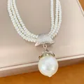 Detailansicht einer luxuriösen dreilagigen Perlenkette aus Acryl mit Barock-Anhänger - Silber-Weiß