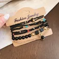 Gros plan d'un ensemble de bracelets bohèmes avec perles noires et dorées - Or-Noir