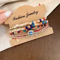 Gros plan d'un ensemble de bracelets en perles bohèmes avec breloques colorées. - Coloré