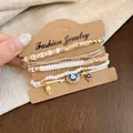 Détail d'un ensemble de bracelets perlés bohèmes avec œil protecteur et main Hamsa - Blanc