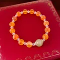 Détail d'un bracelet en perles d'agate orange avec une pierre de jadéite vert pâle - Orange-Vert