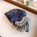 Nahaufnahme der ethnischen Vintage-Stoffhaarklammer mit silbernen Schmetterlingsquasten. - Schmetterling Quasten Stil / Silber-Blau