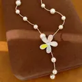 Makroansicht einer Perlenkette mit einem farbenfrohen Zirkonia-Blumenanhänger - Blumen Schlüsselbeinkette (Halskette-Weiß-Rosa-Gelb)