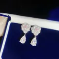 Nahaufnahme von eleganten Blumenohrringen mit funkelnden Zirkonia in Tropfenform - Silber