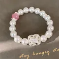 Detailansicht des eleganten quadratischen Zirkonia-Blumenelements auf dem Perlenarmband. - Blumen Quadratischer Anhänger / Weiß-Rosa