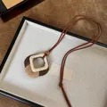 Gedetailleerd zicht op een handgemaakte houten notendop hanger met geweven vezel - Vierkant Frame Vezel Geweven Hanger (3#)