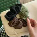 Vue détaillée d'un chouchou patchwork tricolore à pois blancs et texture douce - Chouchou / Noir-Café-Vert
