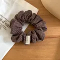 Primo piano di un elastico per capelli a pois marroni con etichetta Hand Made - Pois Caffè