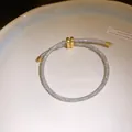 Detail van zirkonia armband met zilveren gaas en verstelbare gouden schuifsluiting - Zilver