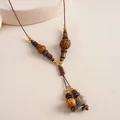 Detailed view of a vintage necklace featuring natural wooden beads and brown cord. - Brown Necklace (Wood Beaded Style)