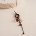 Detailed view of a vintage boho necklace featuring a resin drop and wooden ring - Brown Necklace (Circle Style)