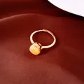 Vista de detalle de anillo abierto chapado en oro 18k con piedra ámbar en tela roja de lujo - Abierto Ajustable / Dorado-Amarillo