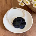 Collier de perles élégant à plusieurs rangs avec un grand ornement de rose en tissu - Fleur noire / Blanc