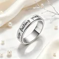 Detail view of engraved 'keep fucking going' text on a stainless steel spinner ring - Silver