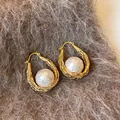 Gros plan de boucles d'oreilles créoles 18 carats en or avec détails de perles baroques - Or (Plaqué Or 18K)