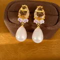 Vue détaillée de boucles d'oreilles dorées avec pierre champagne et perle en forme de poire - Style Perle Goutte d'Eau (HE35484) / Café Rose Or