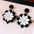 Gros plan de boucles d'oreilles fleurs en acrylique noir et blanc sur un écrin rose élégant - Style Floral Lavis d'Encre (HE35423) / Tige en Argent-Blanc-Noir