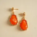 Macro detail of irregular orange resin drop earrings with vintage gold-plated finish - Orange