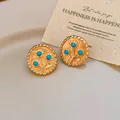 Elegante gouden ronde oorknopjes met reliëfbloemen en blauwe hars turkooizen kralen - Bloemvorm / Goud/Blauw