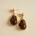 Detailed view of vintage gold earrings with irregular dark brown marbled resin charms - Brown
