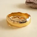 Detailaufnahme eines massiven goldfarbenen Armreifs mit organischer Wellenstruktur. - Goldwelle (Umweltfreundlich)