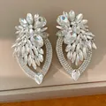 Gros plan détaillé de boucles d'oreilles fleurs en cristal de style occidental. - Blanc