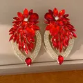 Détail de grandes boucles d'oreilles fleur en cristal rouge avec cadres en goutte. - Rouge