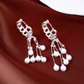 Macro detail van zilveren schakeloorbellen met elegante hangende parelkwastjes - Ronde Parel Kwastje Stijl / Zilver