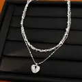 Vista detallada de un collar de doble capa con cuentas y colgante de corazón de circón - Plateado